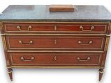 an antique chest of drawers with marble top and brass handles