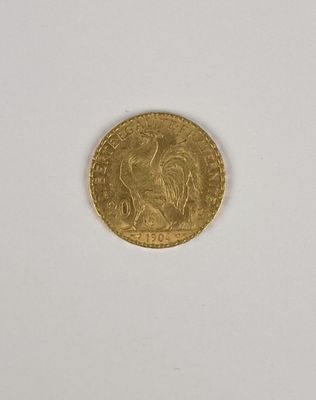 gros plan d'une pièce d'or sur une surface blanche