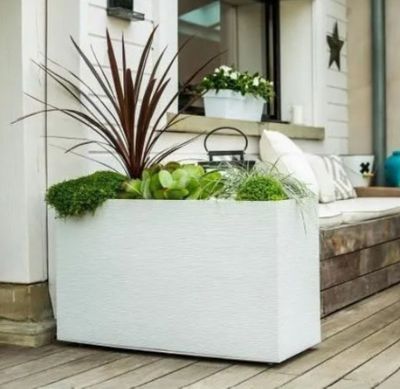 a white planter sitting on the porch of a house