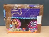 the dog is sitting in the box on the table next to the toy