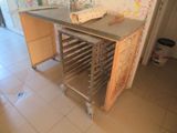 une table sur laquelle sont posés plusieurs plateaux, dans une pièce