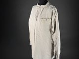 a white shirt on a mannequin stand against a black background