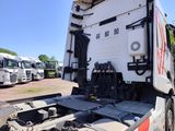 a large white truck parked in a lot with other trucks in the background