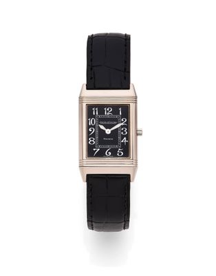 un gros plan d'une montre sur une surface blanche avec un fond blanc