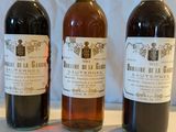 trois bouteilles de vin posées sur une table, l'une à côté de l'autre