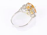 an image of a ring with an orange stone surrounded by white diamonds
