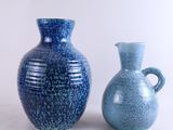 deux vases bleus posés l'un à côté de l'autre sur une table