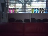 a red couch sitting in front of a window with bottles on it