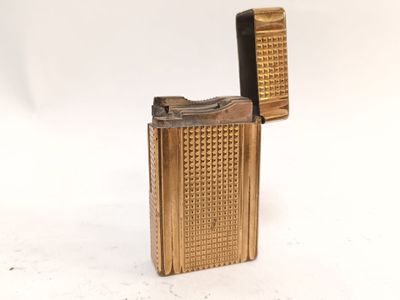 un briquet doré posé sur une surface blanche