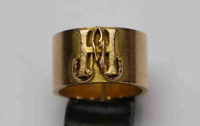 un gros plan d'une bague en or sur laquelle figure la lettre h
