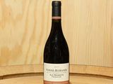 une bouteille de vin posée sur un tonneau