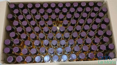 une boîte remplie de bouteilles avec des bouchons violets