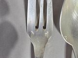 two spoons and a fork that are on a table