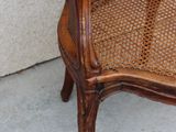 une vieille chaise peinte en marron et ornée d'une fleur verte