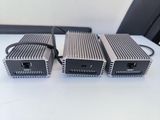 three power supplies sitting on top of a white table next to a black chair