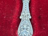 a silver spoon with a handle on a red cloth
