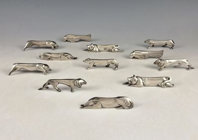 silver plated figurines of animals arranged in a circle on a white surface