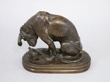 statue en bronze représentant un chien et un chat, posée sur un socle en bois