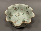a small bowl with flowers on it on a table