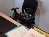 a desk with a computer monitor, keyboard, and papers on it