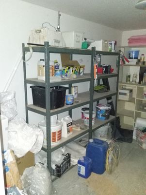 une pièce où il y a beaucoup de cartons, empilés les uns sur les autres sur les étagères