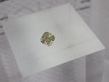 a close up of a yellow diamond sitting on top of a white table