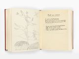 un livre ouvert sur lequel figurent le dessin d'une plante et d'un oiseau