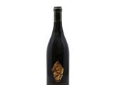 a bottle of wine sitting on top of a white surface