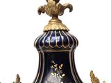 a large blue vase with a gold decoration on it