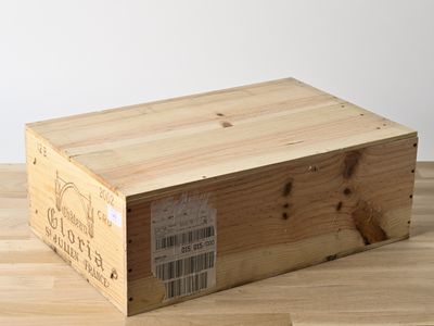 une boîte en bois portant une étiquette, posée sur un parquet