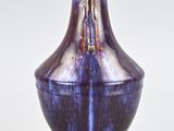 a purple vase that is sitting on a white surface