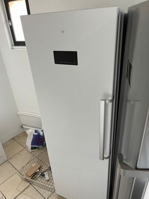 un réfrigérateur blanc dans le coin d'une pièce