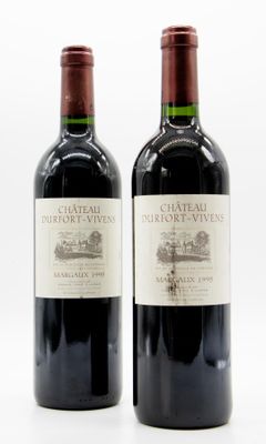deux bouteilles de vin rouge posées l'une à côté de l'autre sur une surface blanche