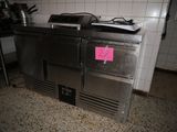 a stainless steel counter with a pink sticker on it
