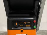 a close up of an orange and black machine on a white surface