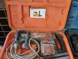 une mallette à outils orange, contenant des outils, posée sur une table