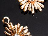 trois bijoux en or posés sur un fond noir