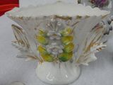a white vase with yellow flowers on it on a table