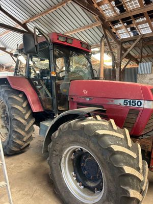 a red tractor that is parked in a barn