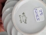a close up of a white vase with a tag on it