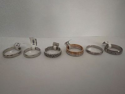 several different types of rings are lined up on a white surface