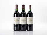 trois bouteilles de vin rouge posées l'une à côté de l'autre sur une surface blanche