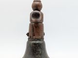 an old bell is sitting on a white surface with a white background
