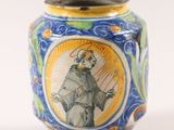 a blue and yellow vase with a picture of a man on it