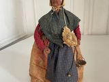 figurine of an old woman in a blue dress with a basket of flowers