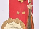 a bottle of perfume next to a card and a bottle of perfume