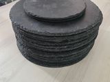 une pile de sous-verres en ardoise posée sur une table