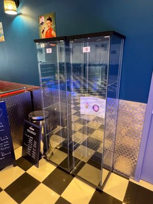une vitrine en verre au milieu d'un sol en damier