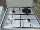 a white stove top oven sitting next to a washing machine