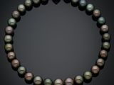 un gros plan d'un collier de perles sur fond noir